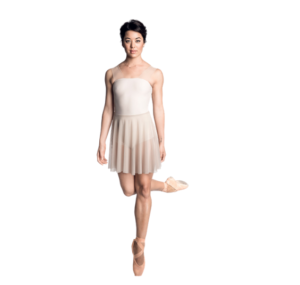 Female dancer standing on pointe on one leg looking at the camera