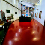 Interior view of a spacious room with a striking red floor and a modern black counter.