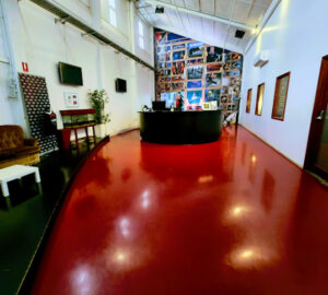 Interior view of a spacious room with a striking red floor and a modern black counter.